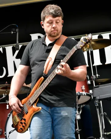 Tom on bass performing outdoors
